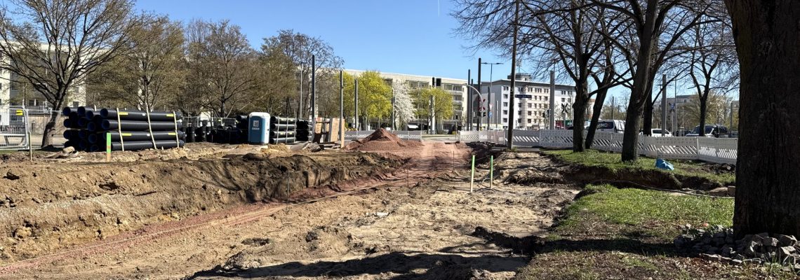 Markierte Holzstäbe stecken im Boden. Diese Abmessungen geben an, wo später Straßenbahn und wo Autos fahren. Die Kritzmannstraße ist in diesem Bereich derzeit komplett aufgerissen.