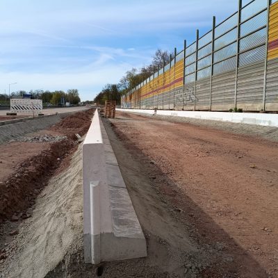 Zwischen den gesetzten Borden führt die neue Gleistrasse ein Stück entlang des Magdeburger Rings. Im Hintergund links ist zu erkennen, dass es auch mit der neuen Asphalttragschicht vorangeht.